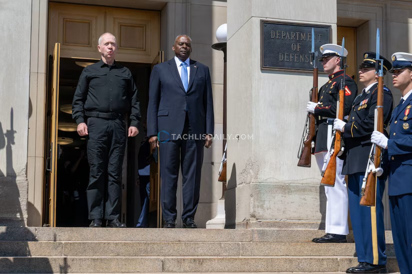 Men stand at top of steps in front of a building.